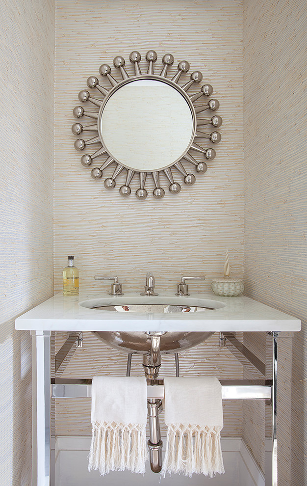 Example of a small trendy powder room design in New York with an undermount sink, marble countertops, beige walls and white countertops