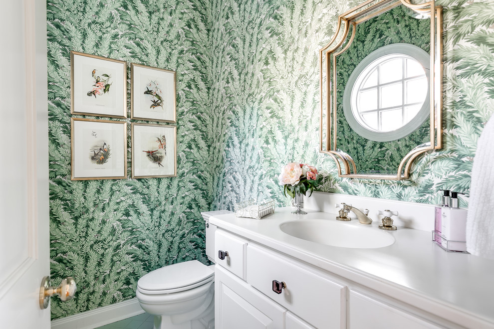 Foto di un bagno di servizio classico con ante con bugna sagomata, ante bianche, WC a due pezzi, pareti verdi, lavabo integrato e top bianco