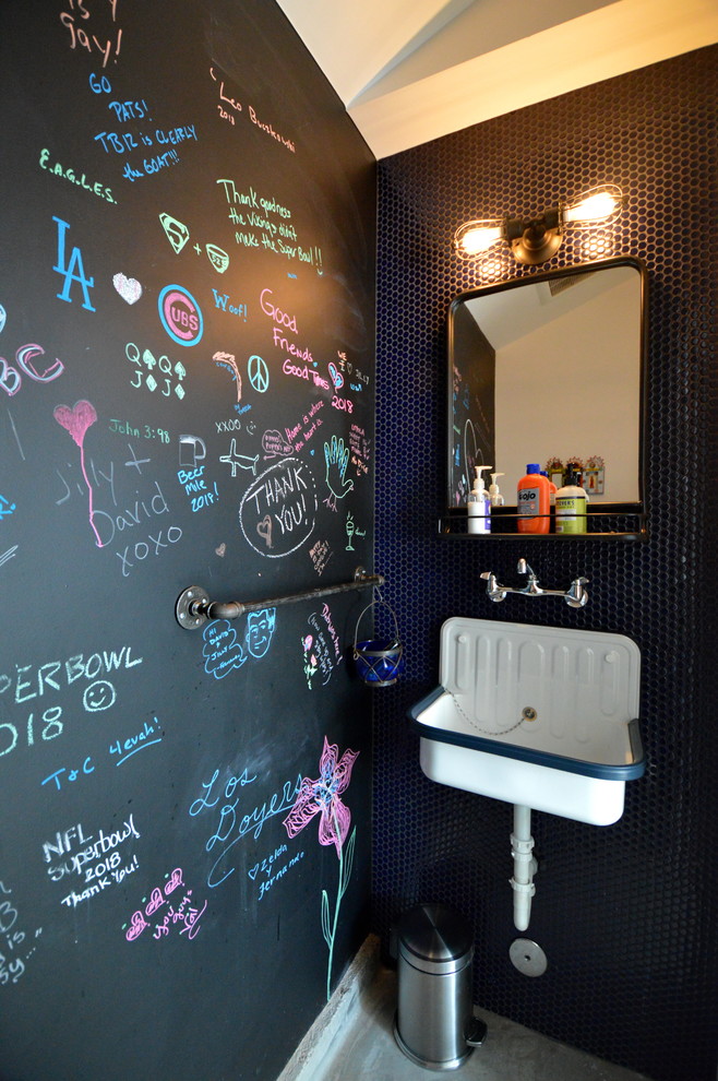 На фото: туалет в стиле фьюжн с черными стенами, подвесной раковиной и серым полом с