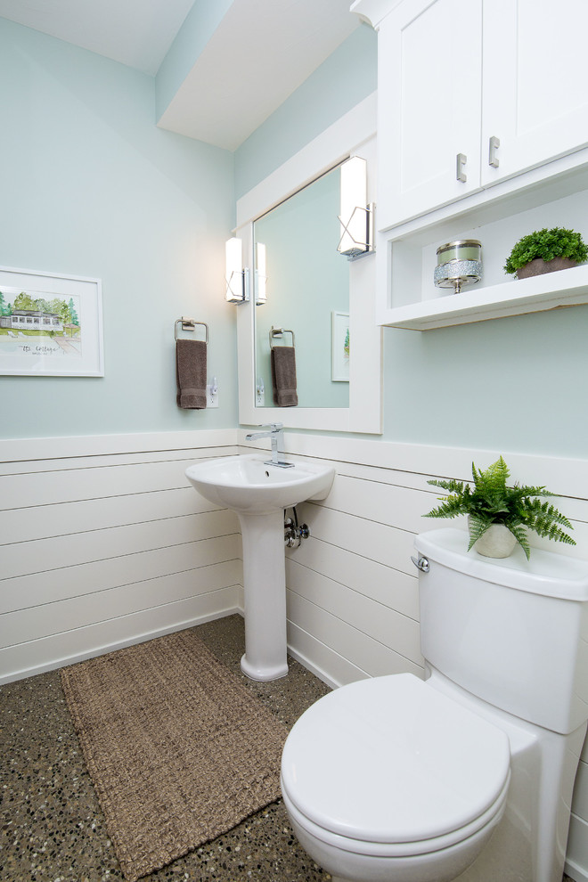 На фото: туалет среднего размера в стиле неоклассика (современная классика) с фасадами в стиле шейкер, белыми фасадами, раздельным унитазом, зелеными стенами, бетонным полом, раковиной с пьедесталом и серым полом с