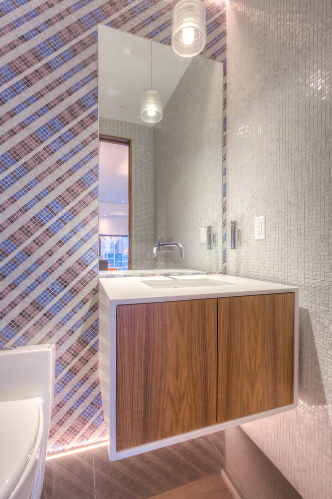 Идея дизайна: огромный туалет в стиле модернизм с монолитной раковиной, плоскими фасадами, светлыми деревянными фасадами, столешницей из кварцита, унитазом-моноблоком, разноцветной плиткой, плиткой мозаикой, белыми стенами и полом из керамической плитки