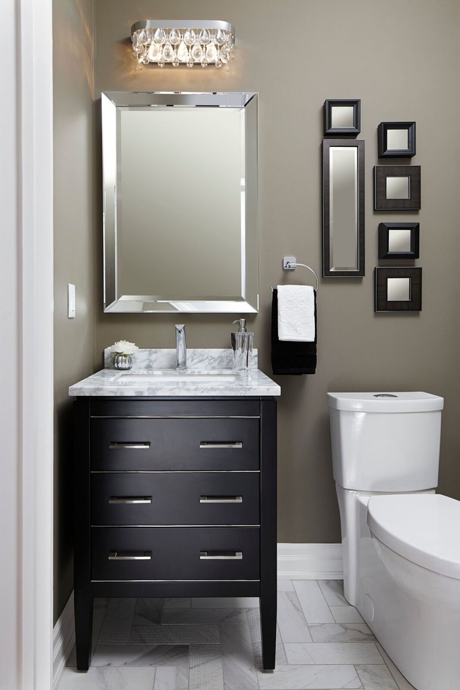 Bild på ett litet vintage vit vitt toalett, med en toalettstol med separat cisternkåpa, grå kakel, porslinskakel, grå väggar, klinkergolv i porslin, ett undermonterad handfat, marmorbänkskiva, luckor med profilerade fronter, svarta skåp och vitt golv
