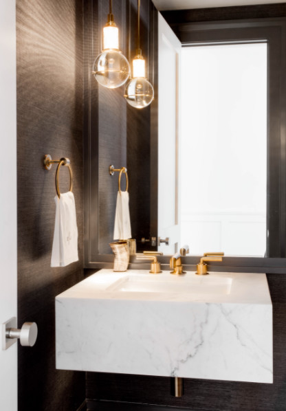 Ispirazione per un piccolo bagno di servizio design con WC monopezzo, pareti marroni, lavabo sospeso, top in marmo e pavimento beige