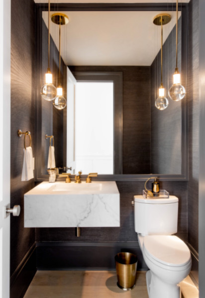 Réalisation d'un petit WC et toilettes design avec WC à poser, un mur marron, un lavabo suspendu, un plan de toilette en marbre et un sol beige.