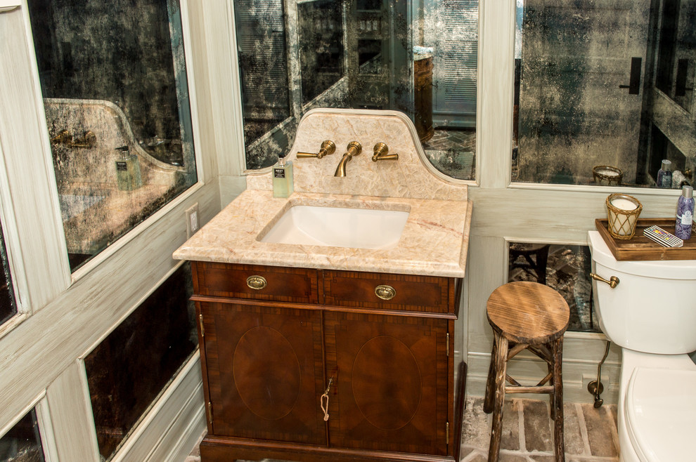 Esempio di un piccolo bagno di servizio minimal con ante lisce, ante in legno scuro, WC monopezzo, pareti beige, pavimento in mattoni, lavabo sottopiano, top in quarzite, piastrelle in pietra e piastrelle beige
