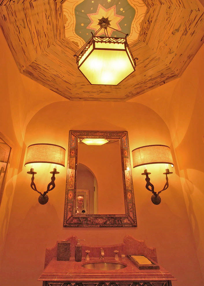 Exemple d'un WC et toilettes méditerranéen de taille moyenne avec un lavabo encastré, un mur orange et un plan de toilette en granite.