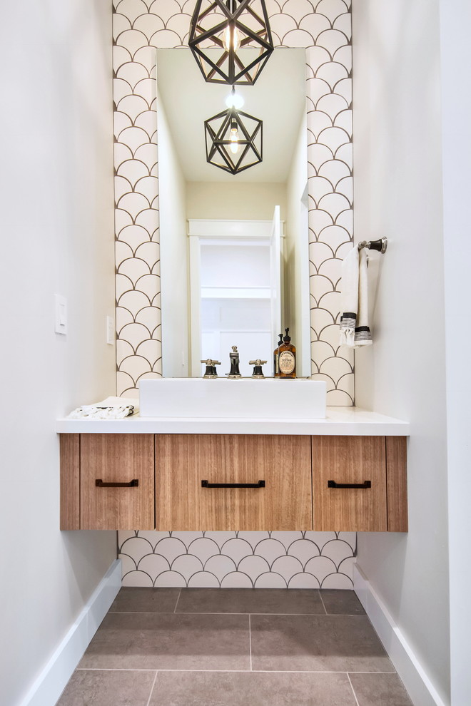 Powder room - mid-sized craftsman white tile and porcelain tile marble floor and gray floor powder room idea in Phoenix with flat-panel cabinets, brown cabinets, a one-piece toilet, quartzite countertops and white countertops