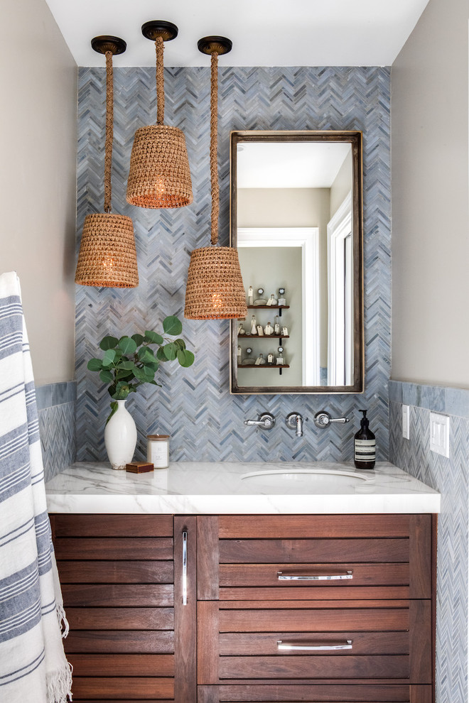 Inspiration for a traditional cloakroom in Orange County with shaker cabinets, dark wood cabinets, beige walls, a submerged sink and white worktops.