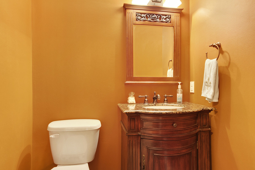 Inspiration pour un grand WC et toilettes traditionnel en bois brun avec un lavabo encastré, un placard en trompe-l'oeil, un plan de toilette en granite et WC séparés.