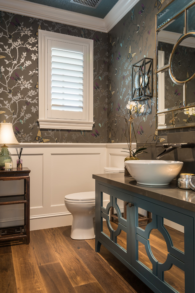 Foto di un bagno di servizio tradizionale con consolle stile comò, ante blu, pareti grigie, lavabo a bacinella, pavimento marrone, pavimento in legno massello medio e top grigio