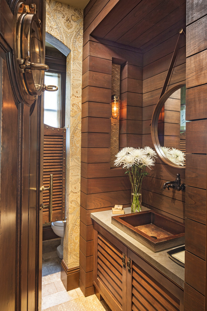 Foto på ett maritimt toalett, med ett fristående handfat, skåp i mellenmörkt trä och beige kakel