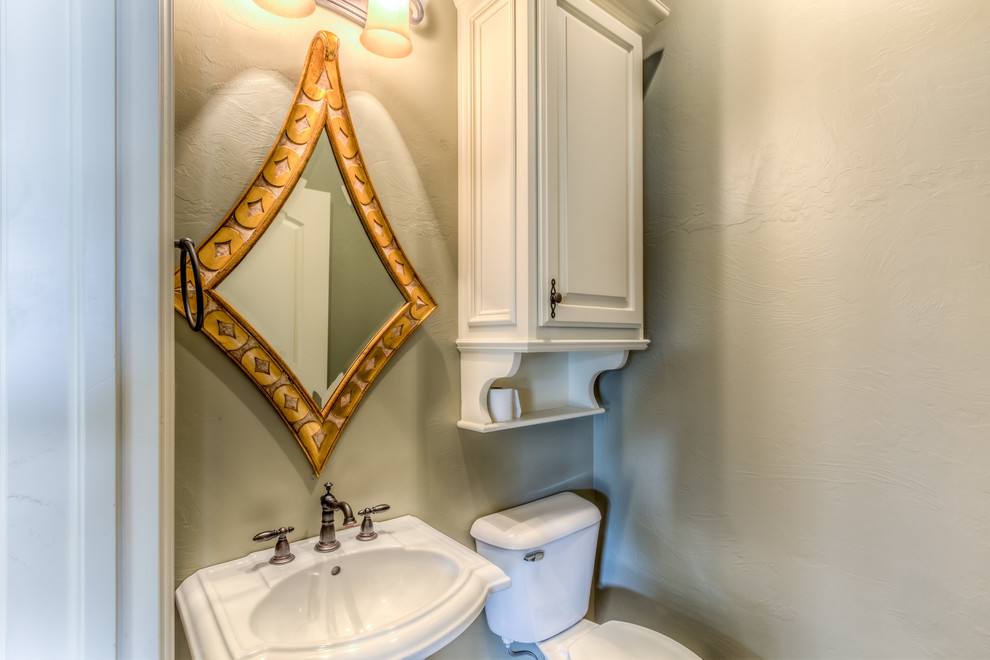 Foto på ett mellanstort rustikt toalett, med ett piedestal handfat, luckor med upphöjd panel, vita skåp, en toalettstol med separat cisternkåpa, beige kakel, porslinskakel, beige väggar och klinkergolv i porslin