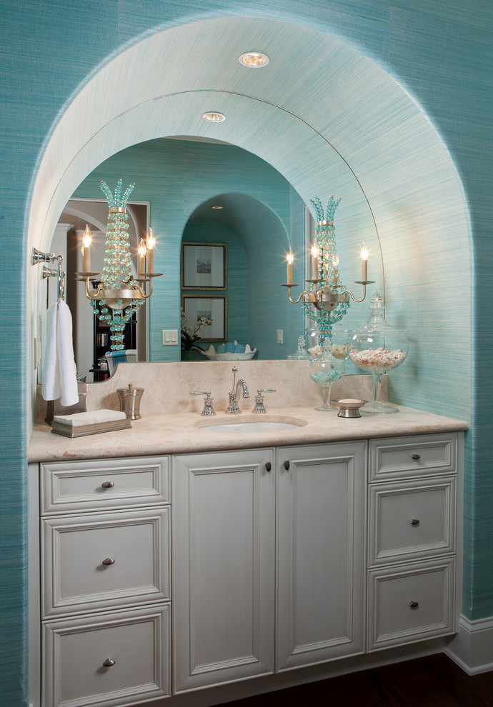 マイアミにあるトロピカルスタイルのおしゃれなトイレ・洗面所 (アンダーカウンター洗面器、落し込みパネル扉のキャビネット、グレーのキャビネット) の写真
