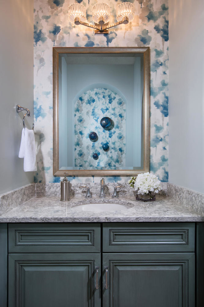 Immagine di un piccolo bagno di servizio stile marino con ante con bugna sagomata, ante blu, top in granito, top grigio, pareti multicolore e lavabo sottopiano