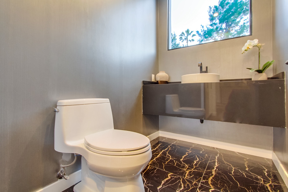 На фото: маленький туалет в современном стиле с унитазом-моноблоком, серыми стенами, полом из керамогранита, настольной раковиной, столешницей из цинка и серым полом для на участке и в саду