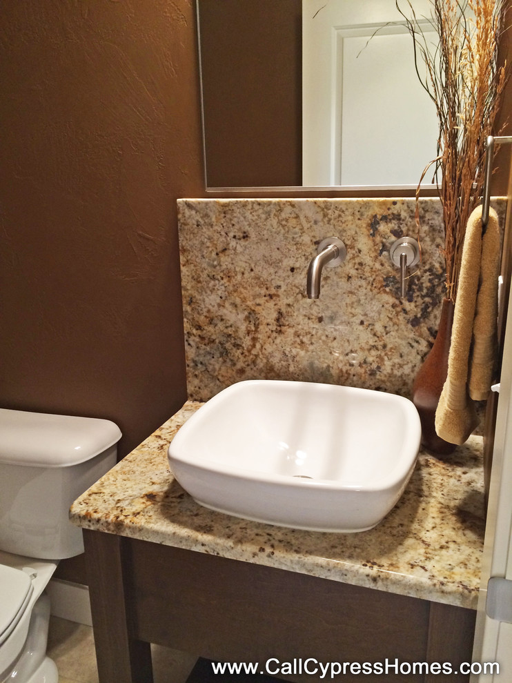 Cette photo montre un WC et toilettes craftsman en bois brun de taille moyenne avec une vasque, un placard en trompe-l'oeil et un plan de toilette en granite.