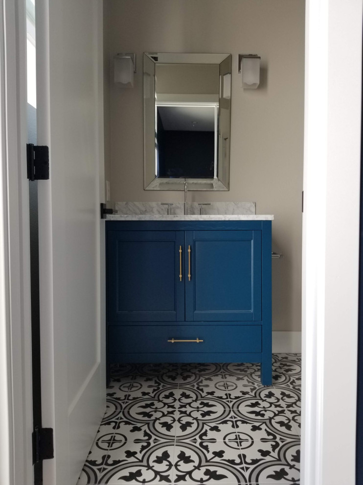 Идея дизайна: туалет среднего размера в современном стиле с фасадами с утопленной филенкой, синими фасадами, бежевыми стенами, полом из цементной плитки, врезной раковиной, мраморной столешницей, разноцветным полом и серой столешницей