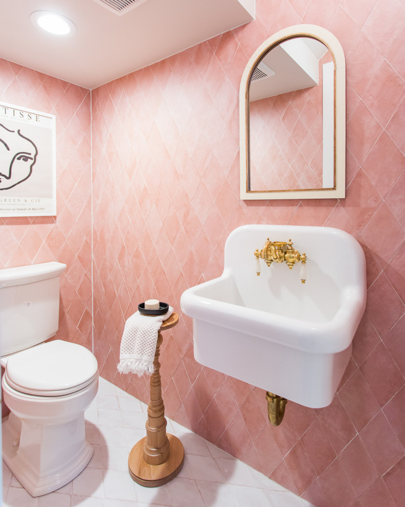 Стильный дизайн: туалет в морском стиле с розовой плиткой, подвесной раковиной и белым полом - последний тренд
