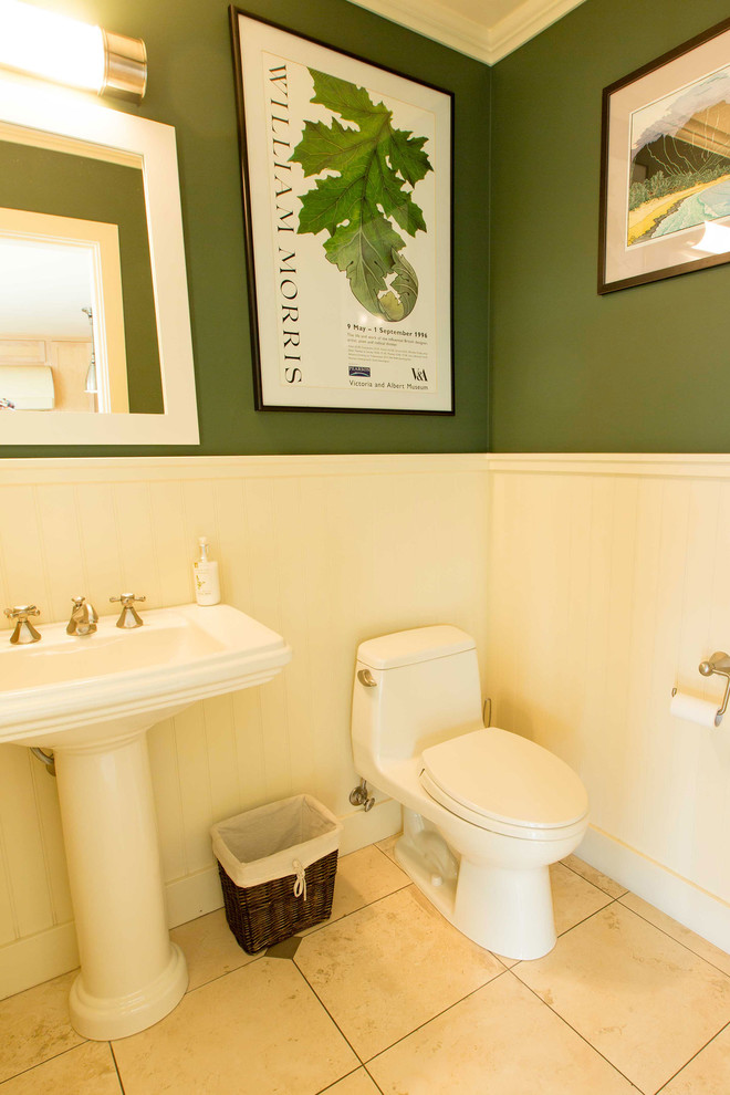 他の地域にある中くらいなトラディショナルスタイルのおしゃれなトイレ・洗面所 (ペデスタルシンク、一体型トイレ	、ベージュのタイル、緑の壁、トラバーチンの床) の写真