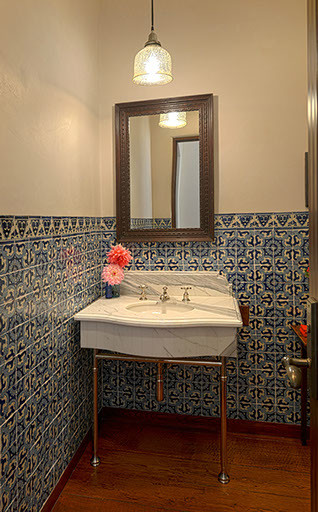 Idées déco pour un WC et toilettes avec un lavabo de ferme, un plan de toilette en marbre, des carreaux de céramique, un mur blanc, un sol en bois brun et un carrelage bleu.