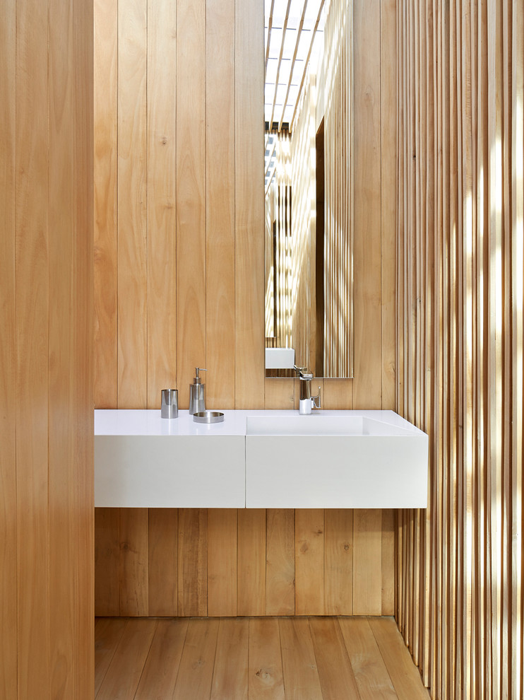 Ispirazione per un bagno di servizio design con lavabo sospeso e pavimento in legno massello medio