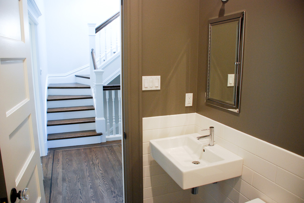 Aménagement d'un petit WC et toilettes victorien avec un carrelage blanc, un mur marron, parquet foncé, un lavabo suspendu et un sol marron.