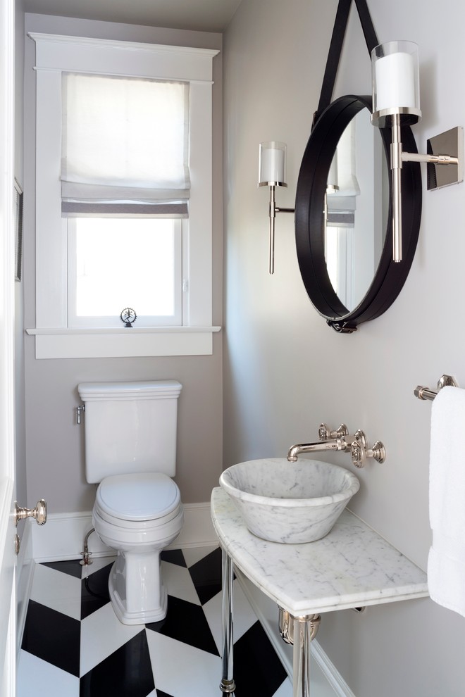 Modern inredning av ett litet toalett, med en toalettstol med separat cisternkåpa, svart och vit kakel, grå väggar, klinkergolv i porslin, ett fristående handfat och marmorbänkskiva