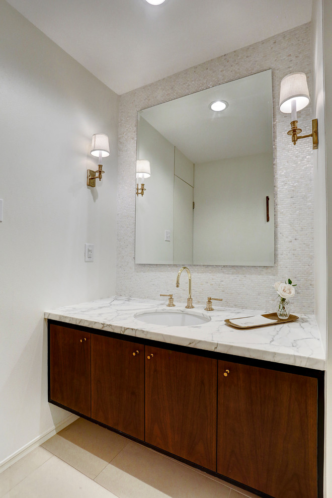 This is an example of a medium sized midcentury cloakroom in Houston with flat-panel cabinets, dark wood cabinets, a one-piece toilet, white tiles, mosaic tiles, white walls, porcelain flooring, a submerged sink, marble worktops, beige floors and white worktops.