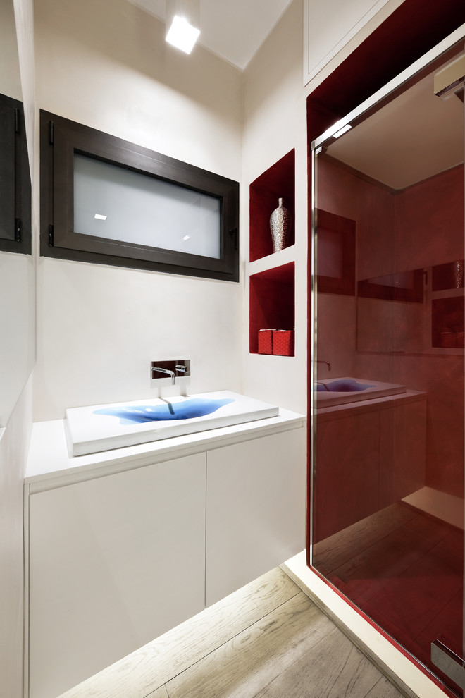 Kleine Moderne Gästetoilette mit Aufsatzwaschbecken, flächenbündigen Schrankfronten, weißen Schränken, weißer Wandfarbe und hellem Holzboden in Rom