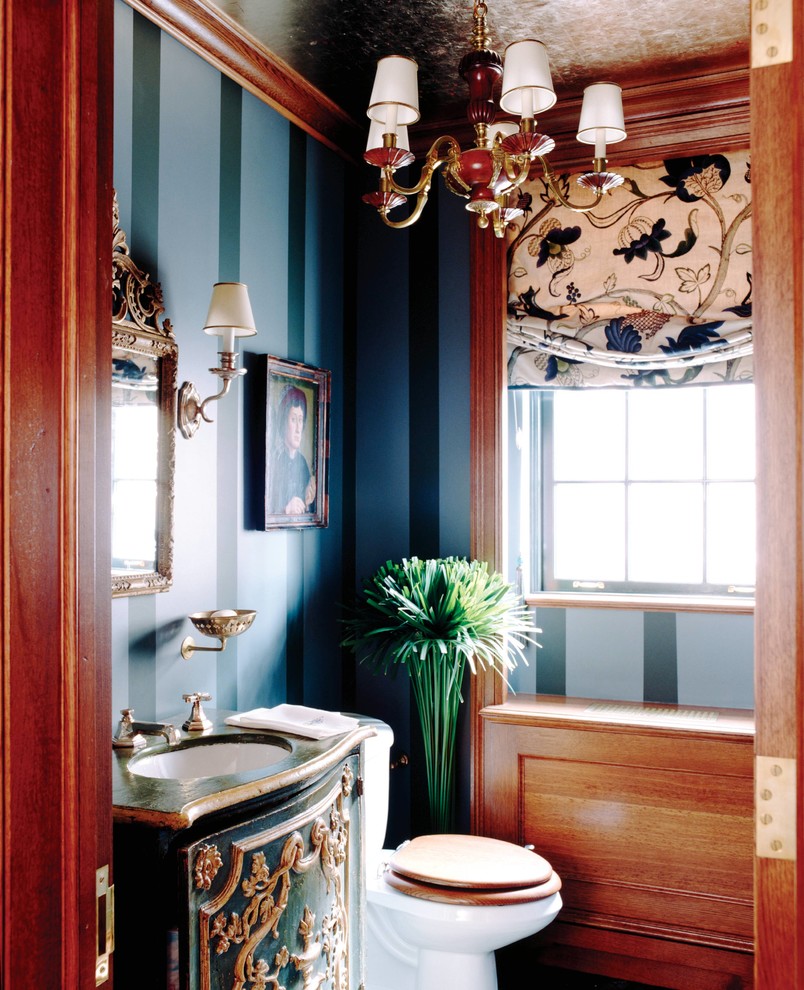Mittelgroße Eklektische Gästetoilette mit verzierten Schränken, grünen Schränken, Wandtoilette mit Spülkasten, blauer Wandfarbe, integriertem Waschbecken, Waschtisch aus Holz und grüner Waschtischplatte in New York