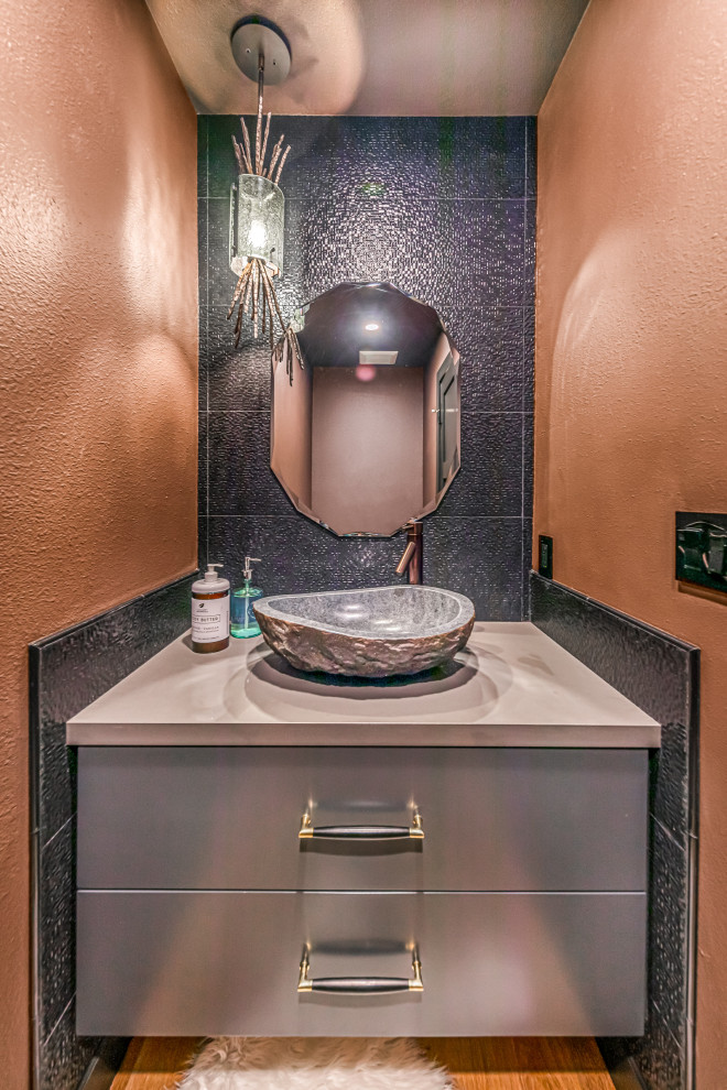Idéer för att renovera ett mellanstort funkis grå grått toalett, med släta luckor, grå kakel, porslinskakel, bänkskiva i kvarts, grå skåp, orange väggar, mellanmörkt trägolv, ett fristående handfat och brunt golv