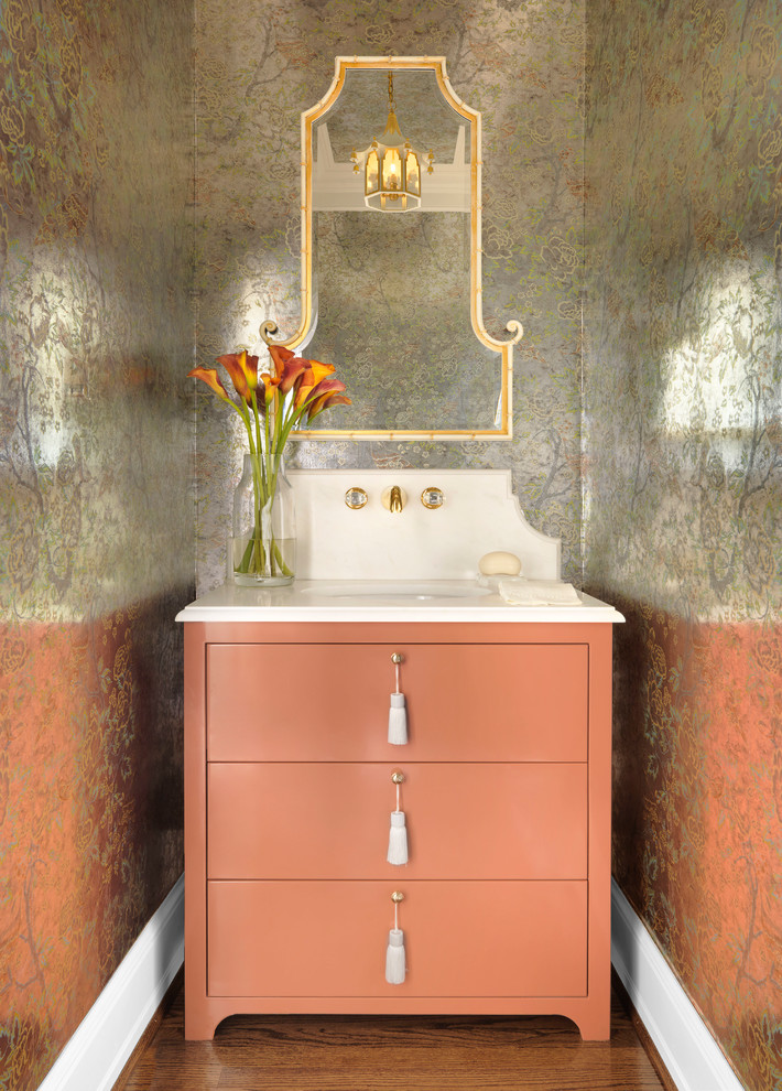 Example of a mid-sized classic medium tone wood floor and brown floor powder room design in St Louis with flat-panel cabinets, an undermount sink, marble countertops, white countertops and orange cabinets