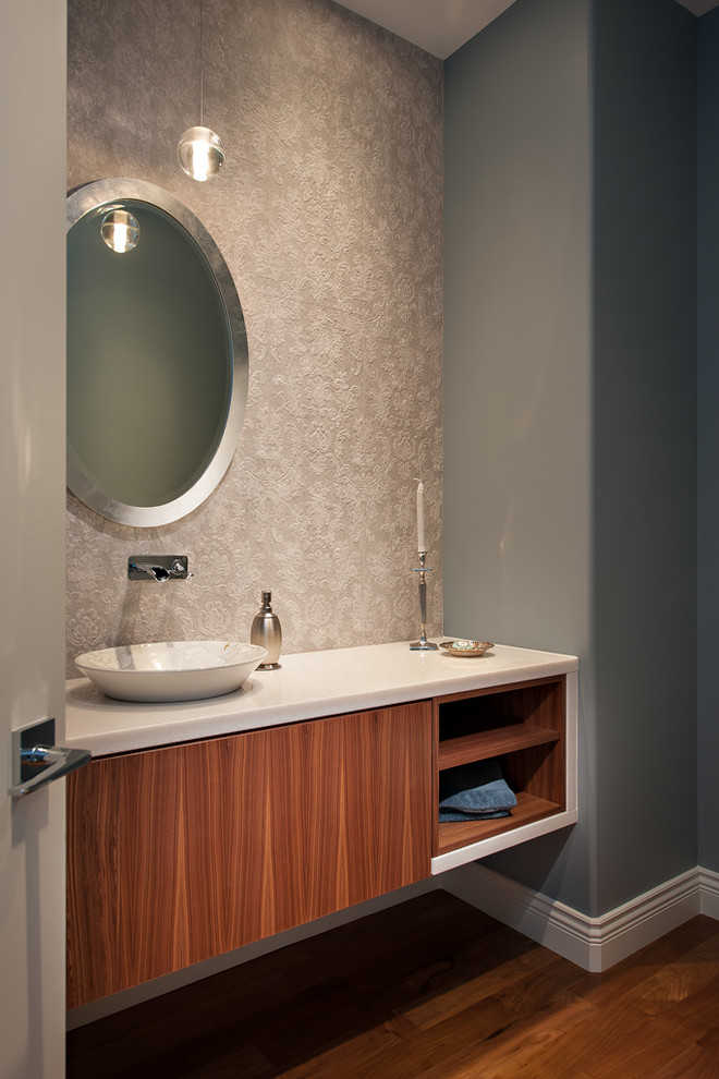 Photo of a medium sized classic cloakroom in Vancouver with flat-panel cabinets, medium wood cabinets, grey walls, dark hardwood flooring, a vessel sink and solid surface worktops.