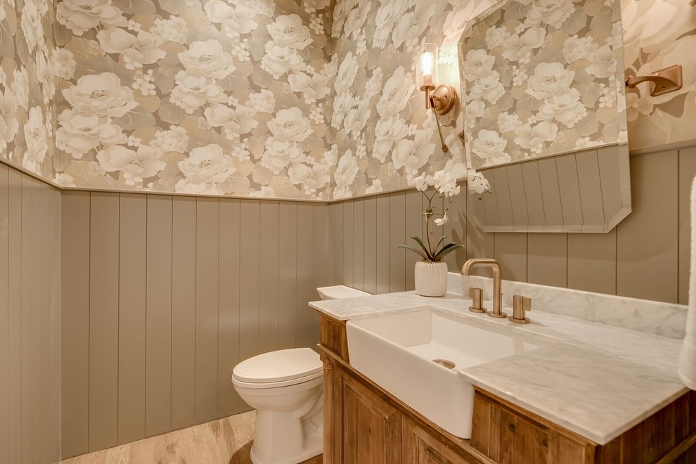 Inspiration för stora lantliga toaletter, med luckor med upphöjd panel, skåp i mellenmörkt trä, en toalettstol med separat cisternkåpa, flerfärgade väggar, ljust trägolv, marmorbänkskiva och brunt golv