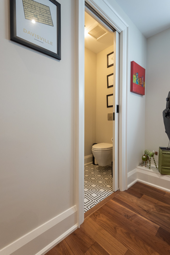 Inspiration pour un petit WC suspendu traditionnel avec un placard en trompe-l'oeil, des portes de placard noires, un mur beige, un sol en carrelage de porcelaine, une vasque, un plan de toilette en marbre, un sol multicolore et un plan de toilette blanc.