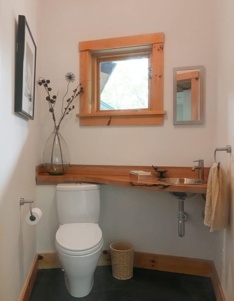 Ispirazione per un piccolo bagno di servizio scandinavo con WC a due pezzi, pareti bianche, pavimento in ardesia, lavabo da incasso, top in legno, pavimento grigio e top marrone
