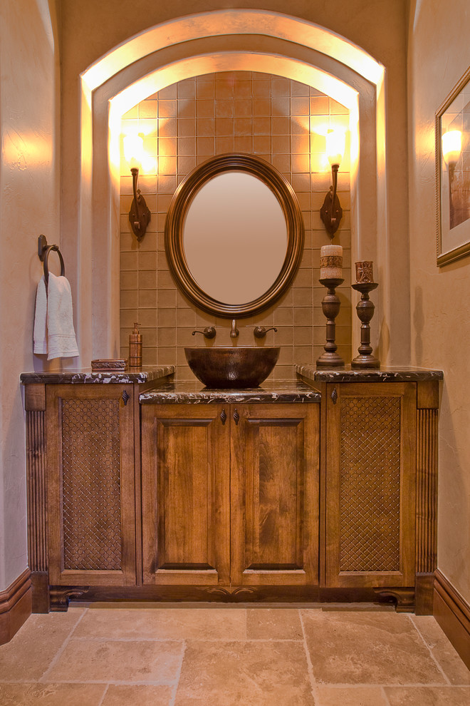 На фото: туалет среднего размера в классическом стиле с фасадами с выступающей филенкой, светлыми деревянными фасадами, стеклянной плиткой, бежевыми стенами, полом из керамической плитки, настольной раковиной и бежевым полом