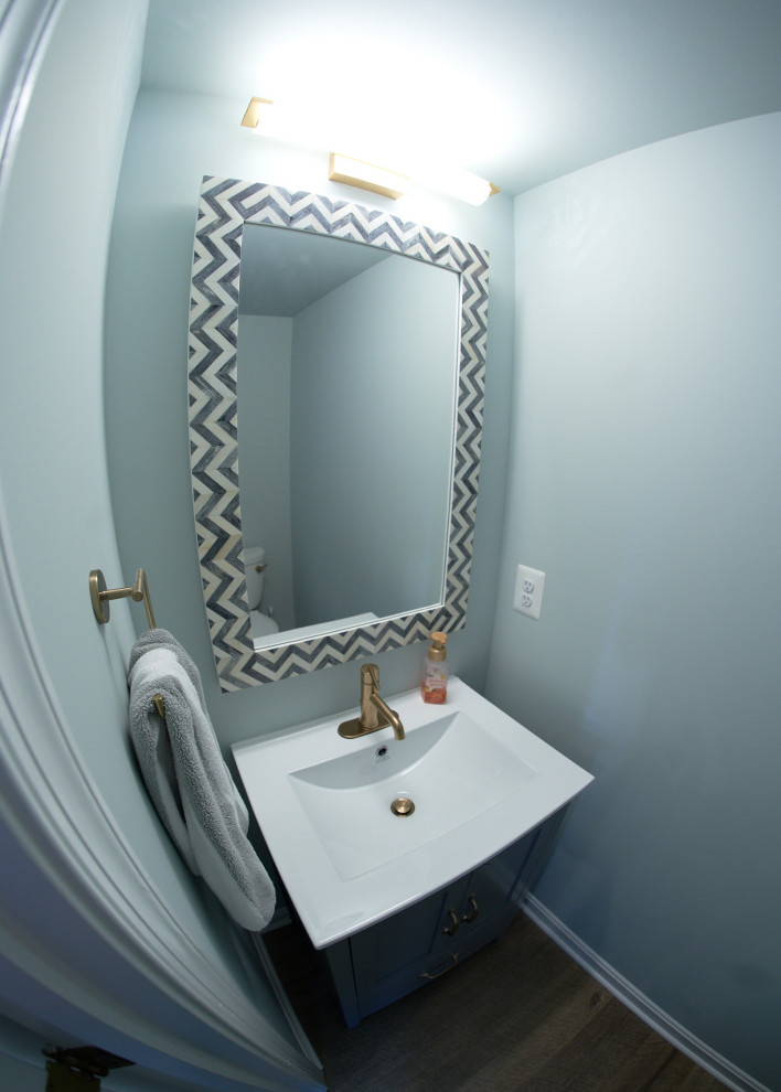 Esempio di un piccolo bagno di servizio tradizionale con ante in stile shaker, ante grigie, pareti blu, pavimento in vinile, lavabo integrato, top in superficie solida, pavimento marrone, top bianco e mobile bagno freestanding