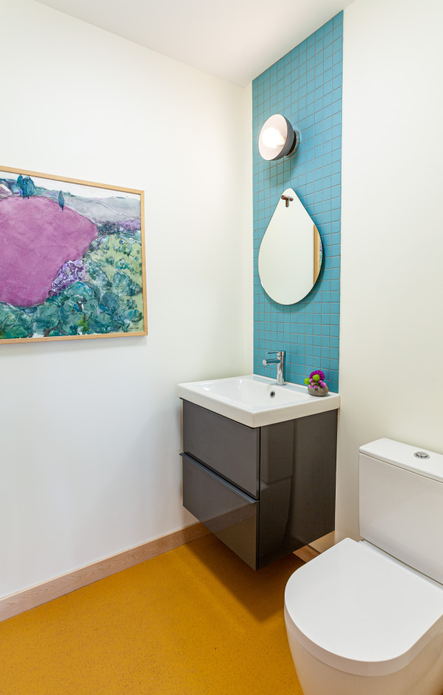 Пример оригинального дизайна: маленький туалет в стиле ретро с плоскими фасадами, серыми фасадами, унитазом-моноблоком, синей плиткой, керамической плиткой, белыми стенами, монолитной раковиной, столешницей из искусственного камня, желтым полом, белой столешницей и подвесной тумбой для на участке и в саду