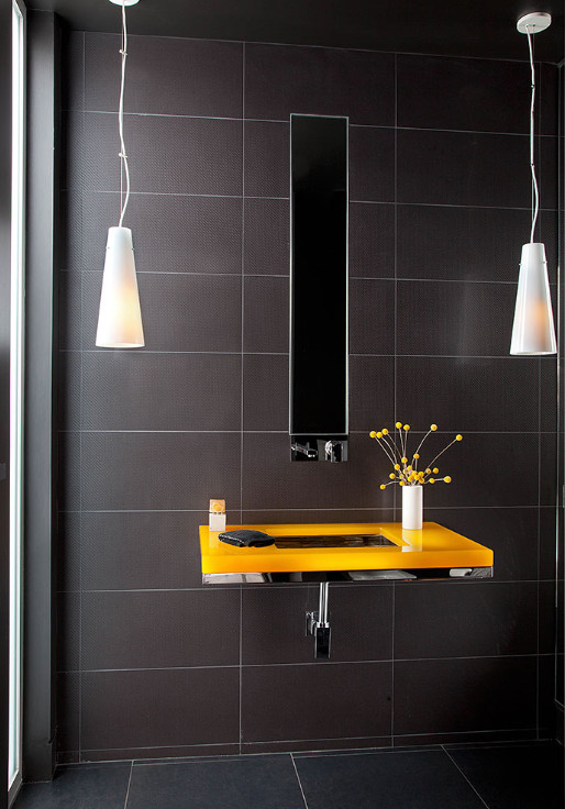 Foto di un piccolo bagno di servizio minimalista con piastrelle nere, piastrelle in gres porcellanato, pareti nere, pavimento in gres porcellanato, lavabo sottopiano, pavimento nero e top giallo
