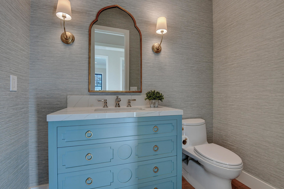 Foto di un bagno di servizio classico di medie dimensioni con consolle stile comò, ante blu, WC monopezzo, pareti grigie, parquet chiaro, lavabo sottopiano, top in quarzite, pavimento beige e top bianco