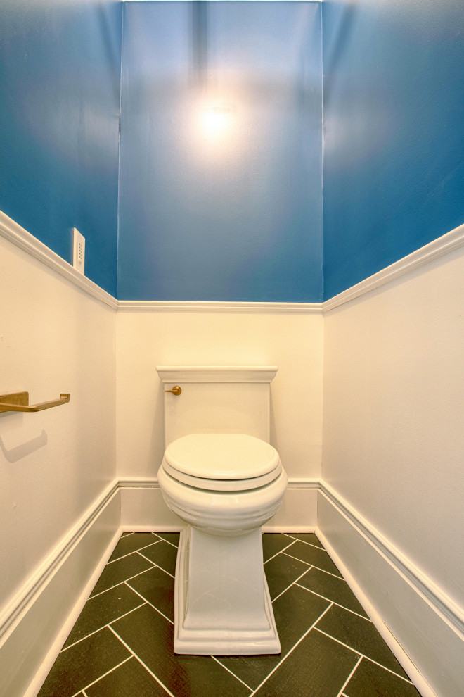 Cette image montre un petit WC et toilettes style shabby chic en bois brun avec un placard en trompe-l'oeil, WC à poser, un mur bleu, un sol en carrelage de porcelaine, un lavabo intégré, un plan de toilette en surface solide, un sol noir, un plan de toilette blanc et meuble-lavabo sur pied.