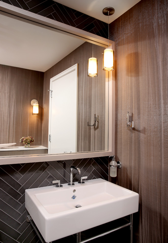 Photo of a small modern cloakroom in Chicago with grey tiles, porcelain tiles, brown walls and a console sink.