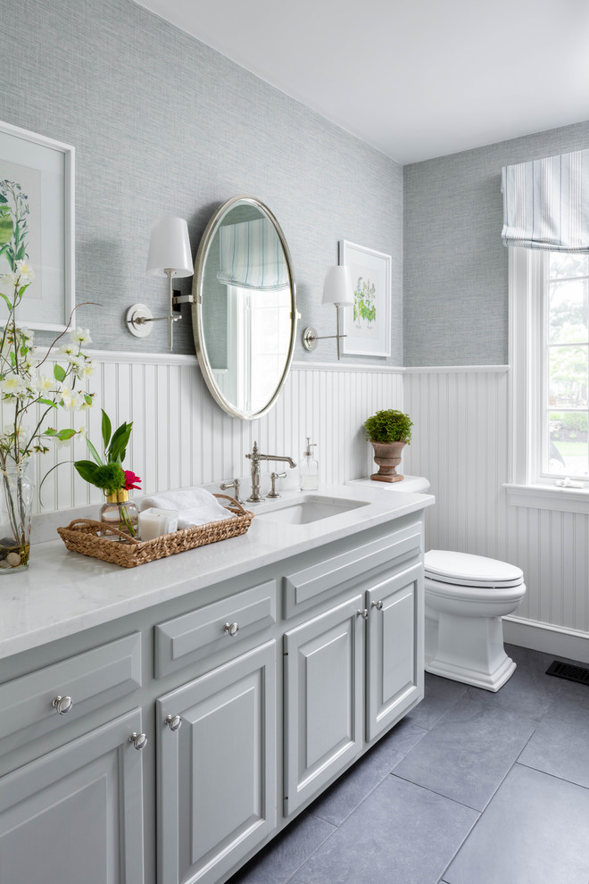 Свежая идея для дизайна: туалет среднего размера в классическом стиле с фасадами с выступающей филенкой, серыми фасадами, серыми стенами, врезной раковиной, серым полом и белой столешницей - отличное фото интерьера