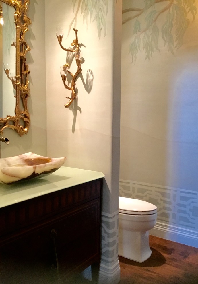 Idées déco pour un petit WC et toilettes asiatique avec un placard en trompe-l'oeil, un carrelage vert, un mur vert, un sol en bois brun, un plan de toilette en verre, un sol marron, un plan de toilette vert et meuble-lavabo sur pied.