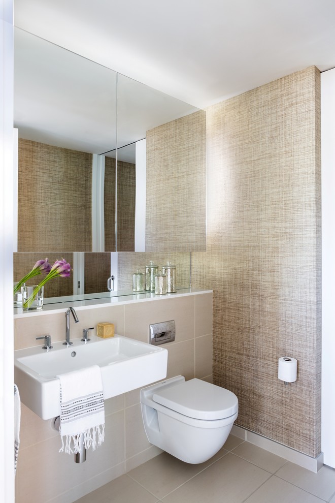 Exempel på ett modernt toalett, med en vägghängd toalettstol, beige kakel, porslinskakel, beige väggar, klinkergolv i porslin, ett väggmonterat handfat och beiget golv