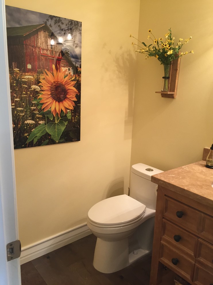 Small eclectic dark wood floor and brown floor powder room photo in Los Angeles with recessed-panel cabinets, medium tone wood cabinets, a one-piece toilet and beige walls