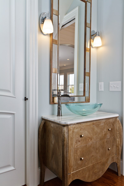 Idées déco pour un WC et toilettes classique en bois brun avec une vasque, un placard en trompe-l'oeil, un plan de toilette en marbre, un mur bleu et un sol en bois brun.