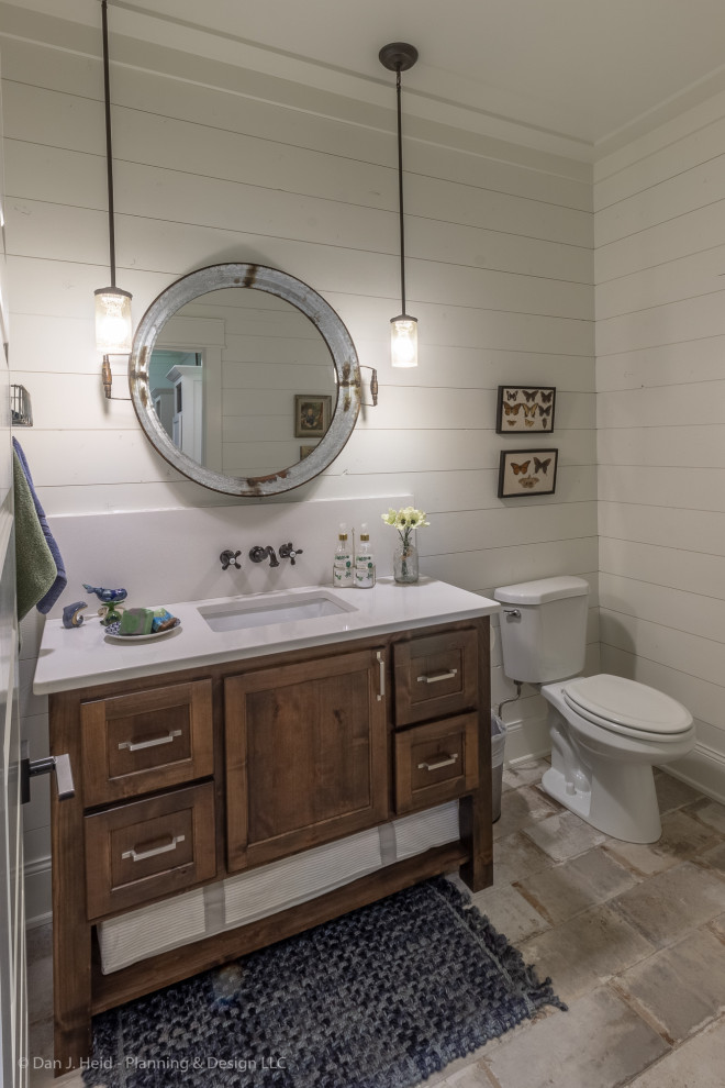 Design ideas for a medium sized rural cloakroom in Minneapolis with flat-panel cabinets, brown cabinets, a two-piece toilet, white walls, ceramic flooring, a submerged sink, solid surface worktops, beige floors and white worktops.
