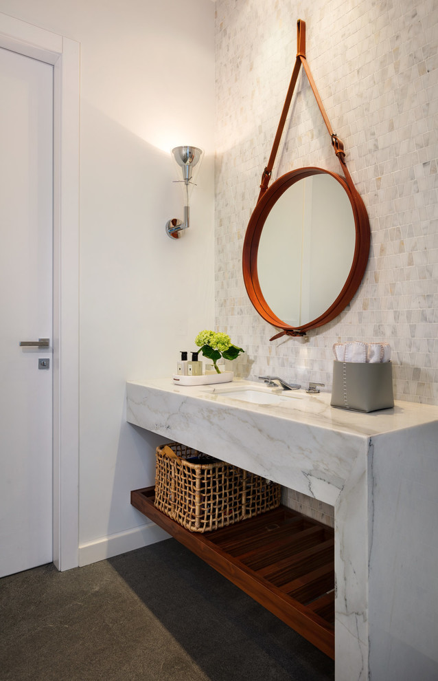 Immagine di un bagno di servizio minimalista di medie dimensioni con ante grigie, piastrelle grigie, piastrelle di marmo, pareti bianche, pavimento in cemento, lavabo sottopiano, top in marmo, pavimento nero e top grigio